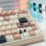 Whimsical Cat PBT dye-sub keycap set displayed from various angles, showcasing charming cat illustrations and cozy coffee-cream colors.