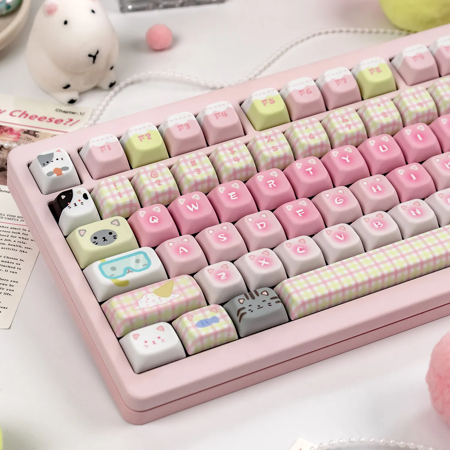 Display of adorable pastel keycaps showcasing mint and pink colors, sweet candy graphics, and charming cat characters in a PBT dye-sub set.