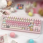 A pastel-themed gallery of PBT keycaps featuring cute cat illustrations, mint-and-pink accents, and soft candy-inspired details.