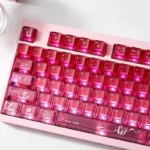A playful gallery showcases luminous transparent pink cinnabar gradient mechanical keycaps set from various angles, highlighting their radiant design.