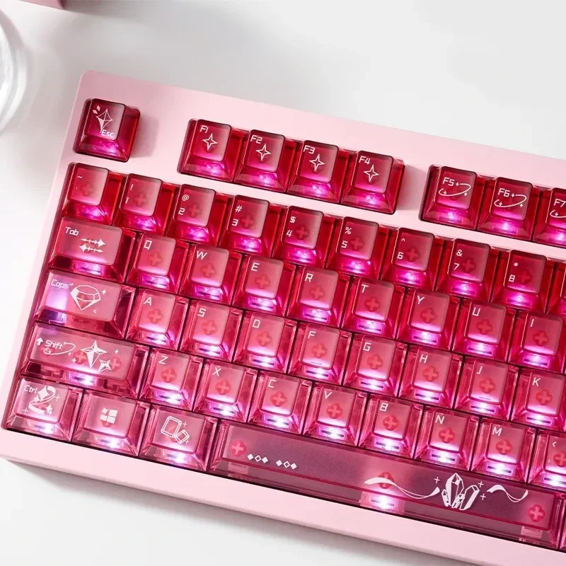A playful gallery showcases luminous transparent pink cinnabar gradient mechanical keycaps set from various angles, highlighting their radiant design.