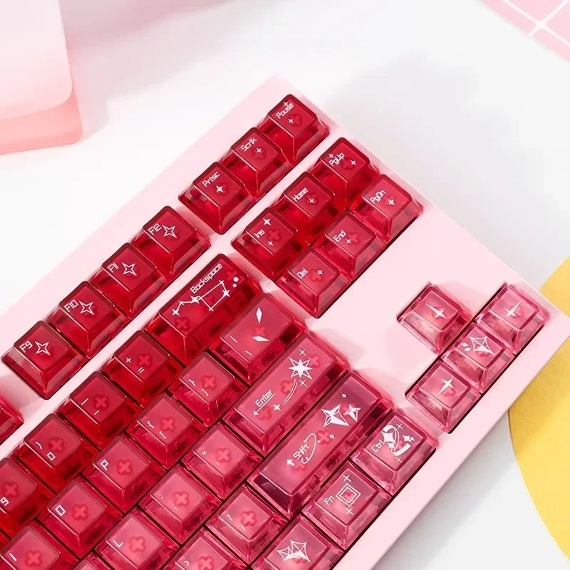 A playful gallery view of luminous, transparent cinnabar pink keycaps set, showcasing their delicate gradient glow and charm from multiple angles.