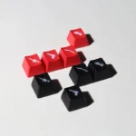 Iconic translucent CSGO weapon keycaps, showcasing vibrant red and black weapon silhouettes illuminated for tactical gaming, viewed from multiple angles.
