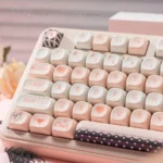 Detailed view of unique Cupid PBT dye-sublimation keycap set, highlighting intricate angelic cherub and heart symbols in a dreamy black and pink palette.