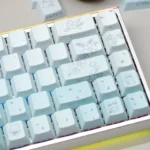 Dreamy gradient custom PBT keycaps set with whimsical rabbit and floral designs, showcasing side-lit effects and artistic detail in a full set.