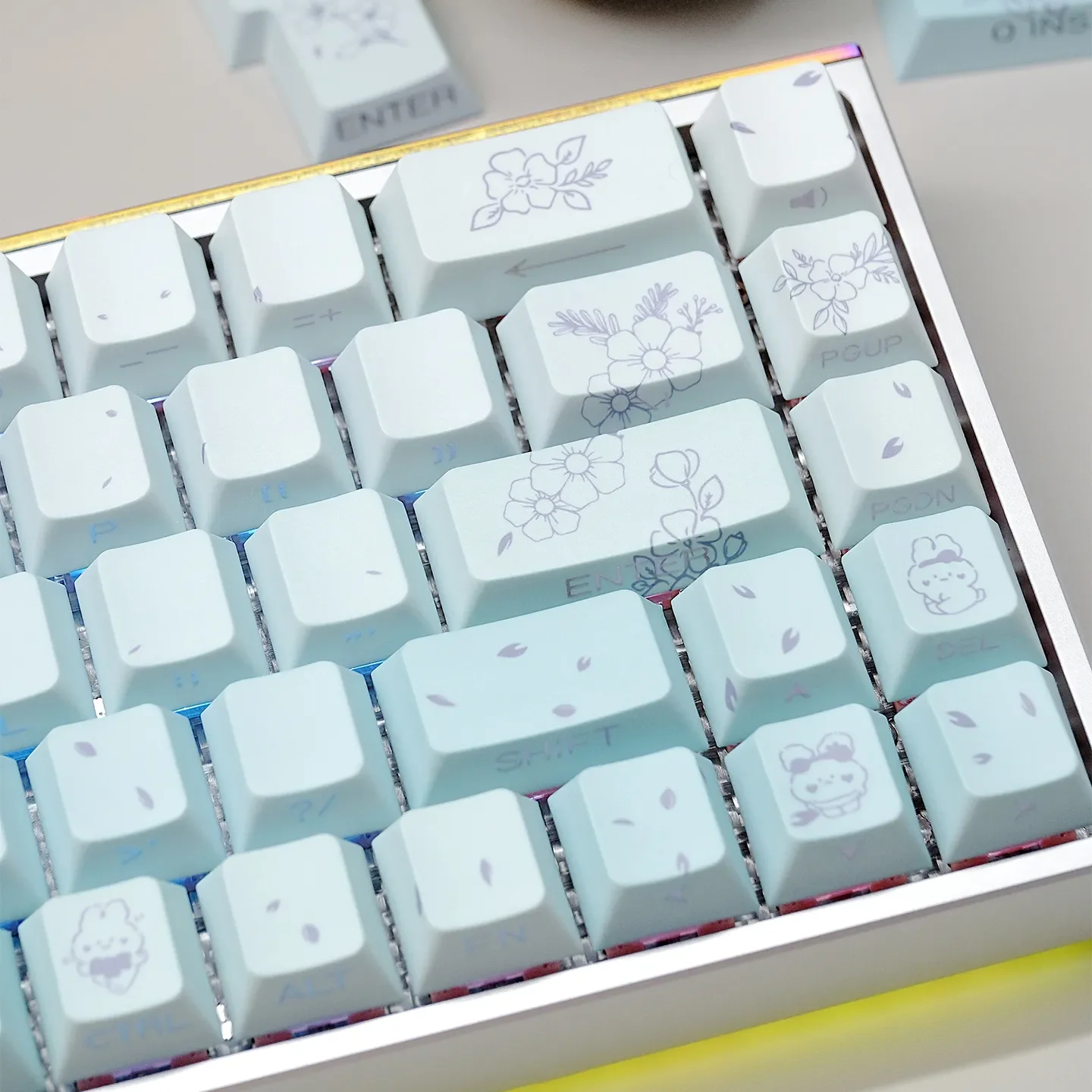 Dreamy gradient custom PBT keycaps set with whimsical rabbit and floral designs, showcasing side-lit effects and artistic detail in a full set.