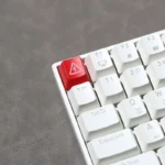 Edgy Danger backlit keycap showcasing its industrial warning sign design from multiple angles with vivid high-contrast lighting for mechanical keyboard.