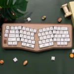 Adorable PBT dye-sublimated dessert keycaps set displayed, featuring a whimsical sweet wonderland of pastel cakes, donuts, and candies.