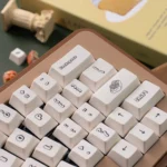 Adorable PBT dye-sublimated dessert keycaps set, showcasing a sweet wonderland of pastel cakes, donuts, and candies from various angles.