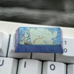 Multiple angles of the handcrafted Frieren Keycap, showcasing its vibrant colorful titanium finish and intricate Elven Mage details.