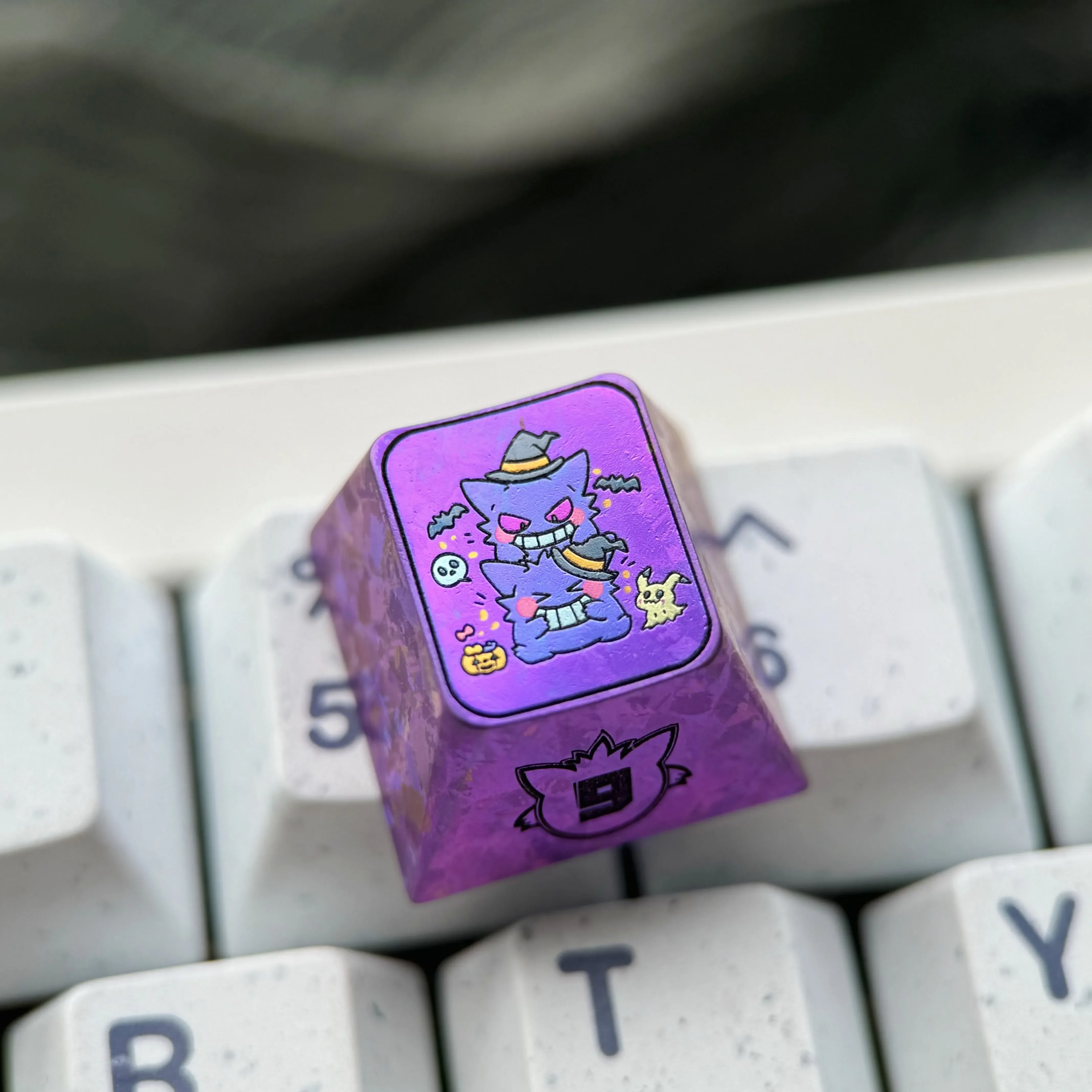 Premium Gengar artisan keycap, expertly crafted from titanium alloy, showcasing a vibrant metallic purple finish and stylized Gengar character.