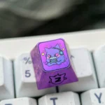 Premium titanium alloy Gengar artisan keycap displayed on a mechanical keyboard, showcasing its stylized metallic purple finish and high-quality setup.