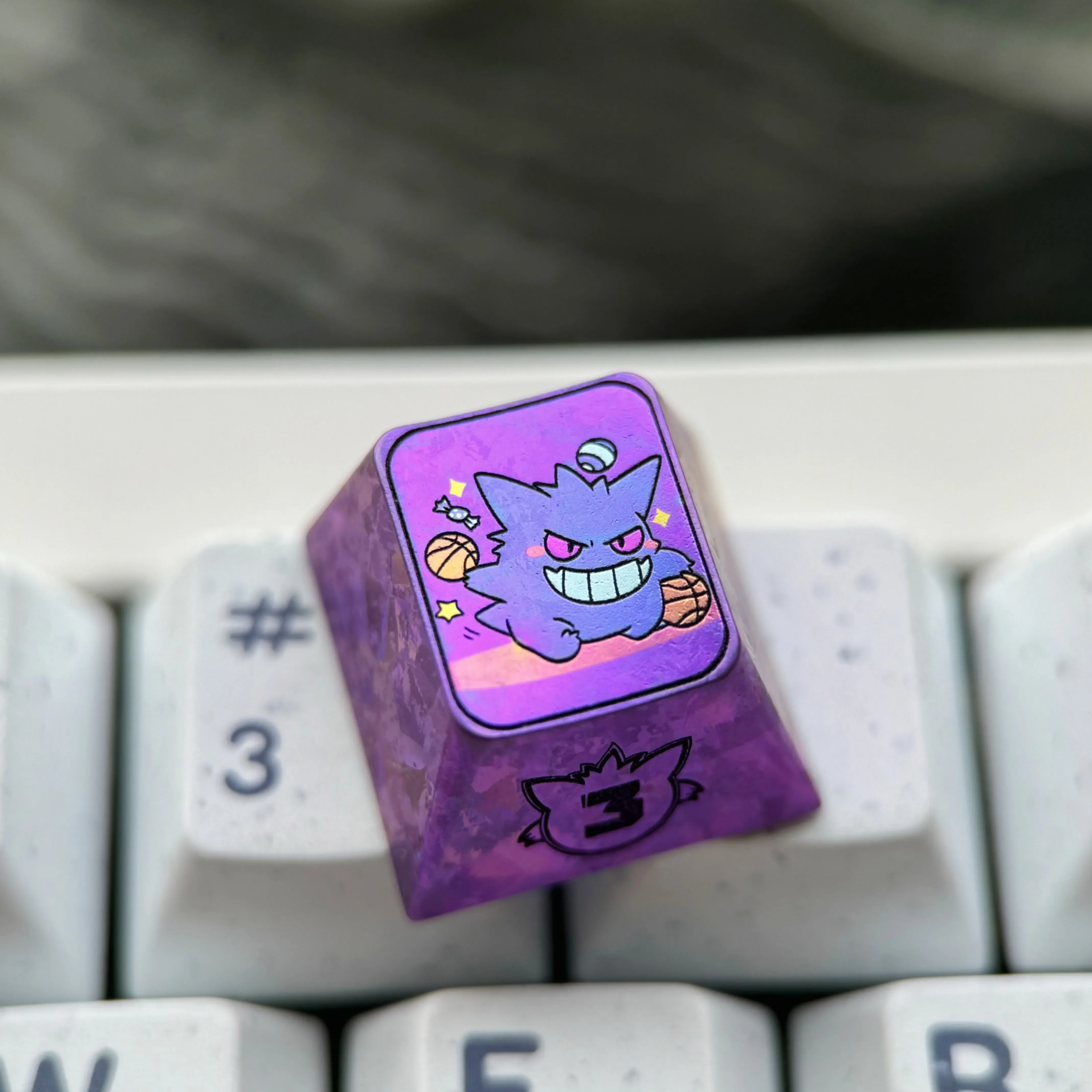 Premium titanium alloy Gengar artisan keycap featuring its stylized metallic purple finish, an artistic custom Pokemon mechanical keyboard accessory.