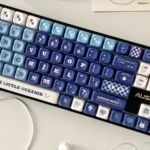 Elegant Furina PBT dye-sub keycap set, angled view showing vibrant blue, white, and gold Fontaine motifs, capturing Genshin Impact artistry.