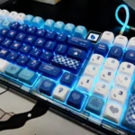 Close-up of elegant Furina PBT dye-sub keycaps set, showcasing vibrant blue, white, and gold Genshin Impact Fontaine motifs from multiple angles.