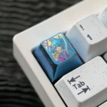 Multiple angles of the exclusive Hatsune Miku titanium keycap, showcasing its vibrant anime aesthetic and premium metallic finish.