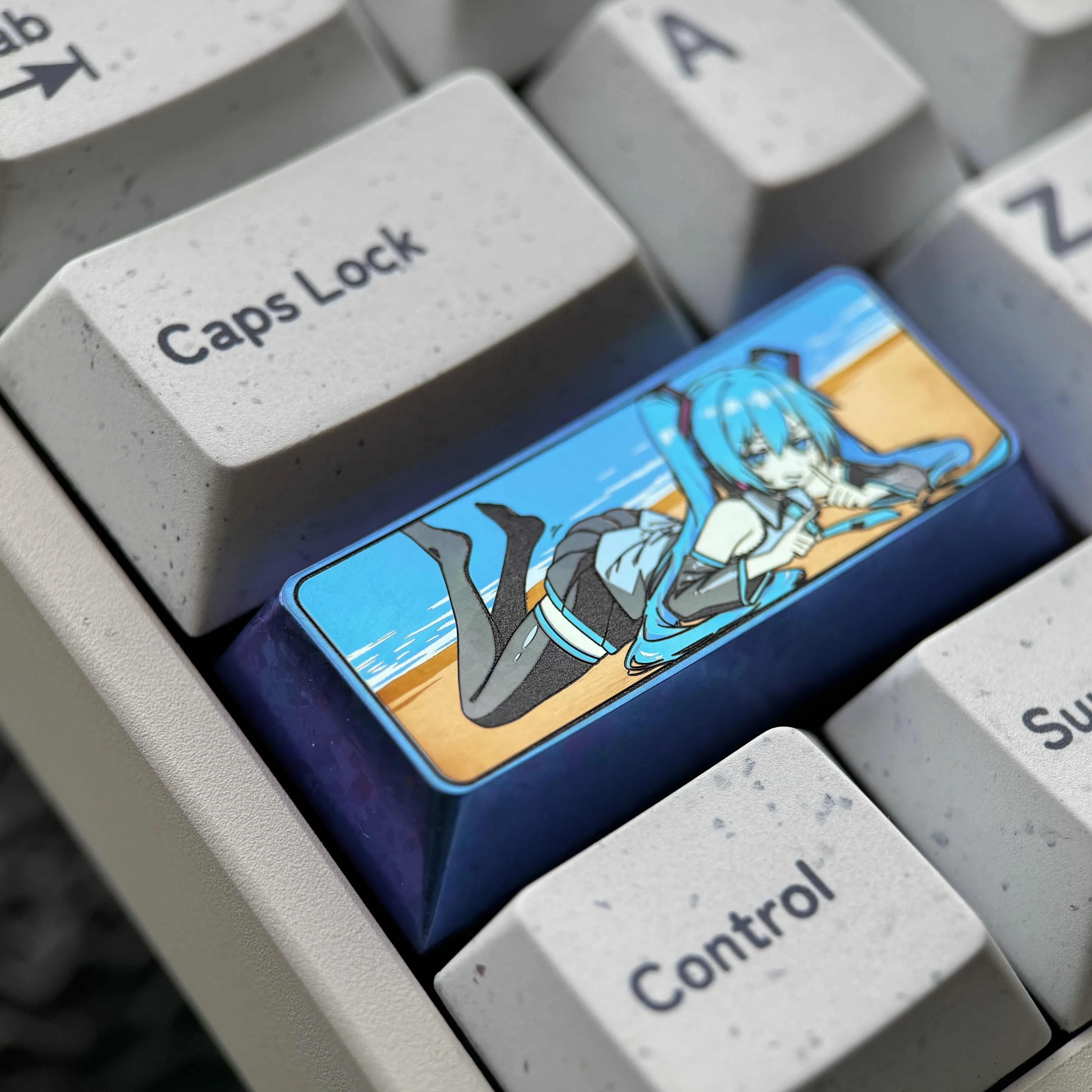 Vibrant Hatsune Miku titanium keycap, showcasing its exclusive colored artistry and aerospace-grade metallic finish for a custom mechanical keyboard.