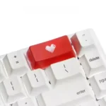 An elegant double-shot ABS heart keycap, showcasing its vibrant backlit translucent red heart icon.