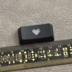 Premium black translucent double-shot ABS backspace keycap featuring a central glowing heart, designed for backlit mechanical keyboards.