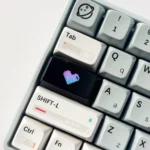 Artistic images of the Luminous Heart Shaped Keycaps, highlighting its subtle illuminated double-shot heart design on a dark design.