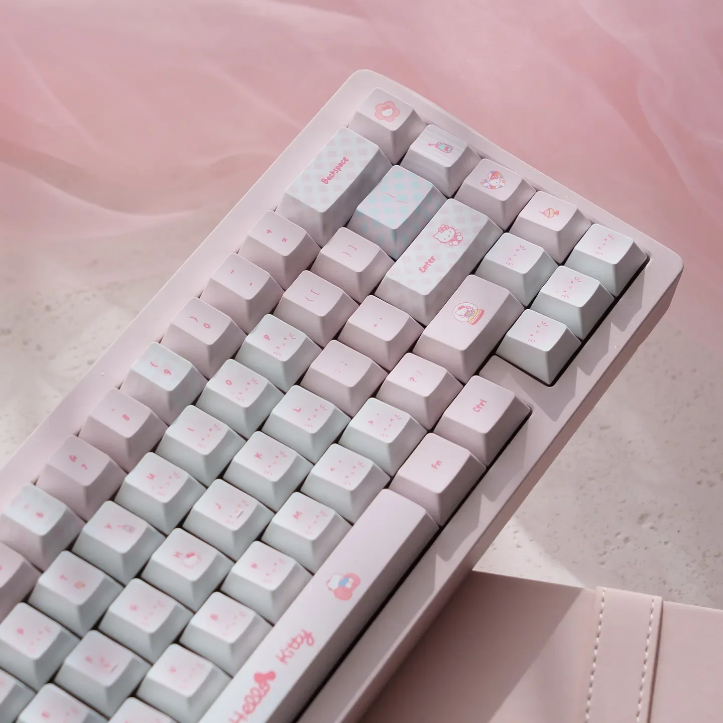 Hello Kitty PBT dye-sub keycap set. Vibrant pink keys with iconic characters showcased from various playful angles, emphasizing durable design.