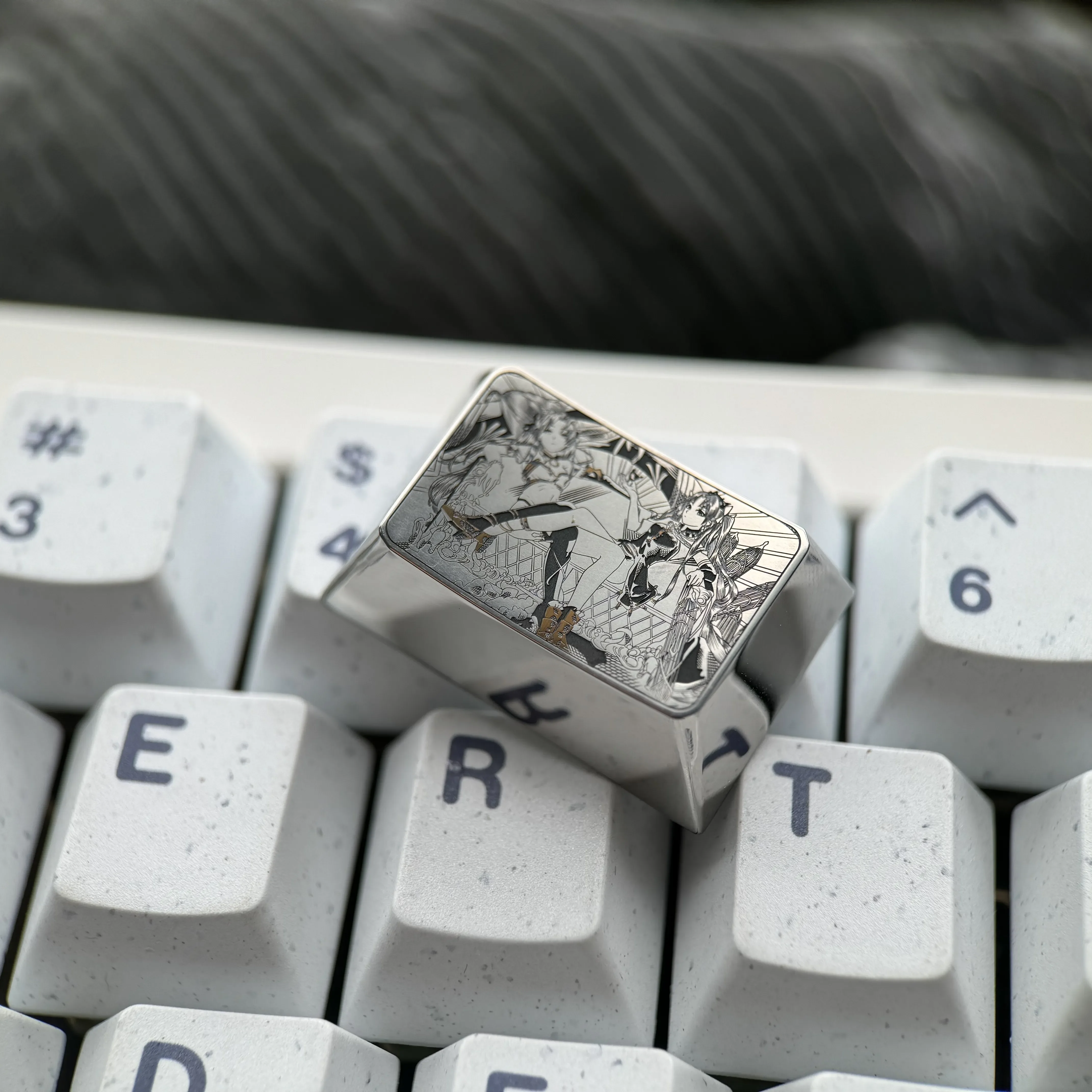 Gallery of the artisan Premium Titanium Ishtar & Ereshkigal Tab Key Keycap, revealing its precision-engraved Fate anime motifs and gleaming metallic surface from various angles.