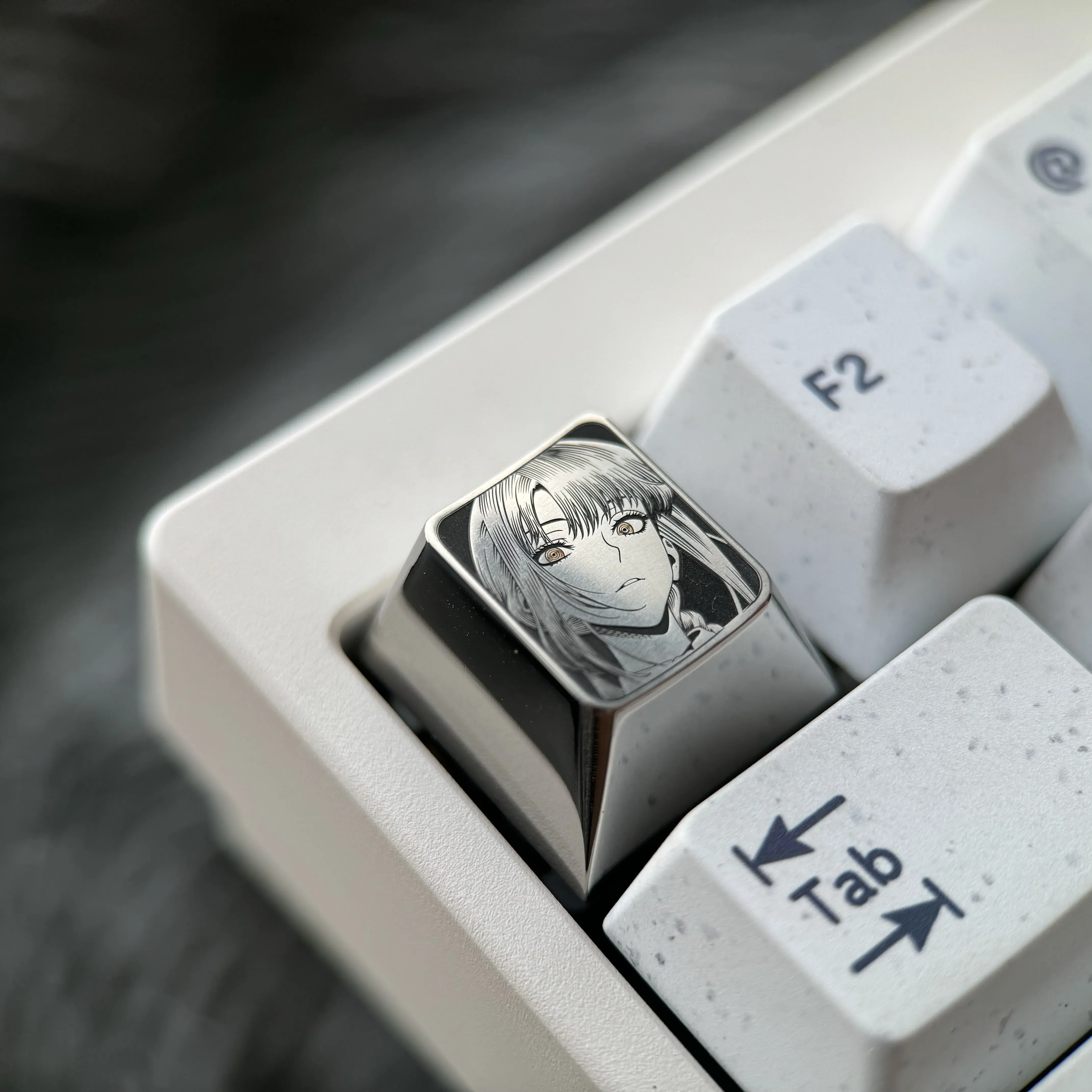Detailed gallery of the precision-engraved Makima Titanium Keycap, highlighting intricate pointillism art and sleek silver finish from various angles.