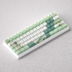 Whimsical Genshin Impact Nahida PBT dye-sub keycaps set, an artistic collection featuring vibrant green and white character motifs displayed.