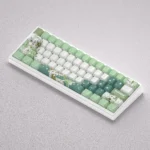 Whimsical Genshin Impact Nahida PBT dye-sub keycaps set displayed from various angles, showcasing vibrant green and white hues and elegant character deisgn.
