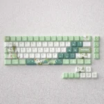 Whimsical Nahida keycaps set for mechanical keyboards, featuring vibrant green PBT dye-sub keycaps with elegant Genshin Impact character motifs.