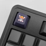 One Piece Keycaps PBT showcasing various iconic pirate flags and emblems from different angles. This premium dye-sublimated keycap set brings the sea to your setup.