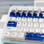Luminous ceramic-like PC keycaps set in sapphire blue and pure white, displayed from multiple angles to highlight their clean, premium aesthetic.