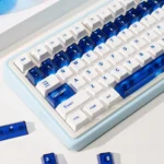 Luminous ceramic-like PC keycaps set in sapphire blue and pure white, showcased from multiple angles to highlight their premium finish and radiant glow.