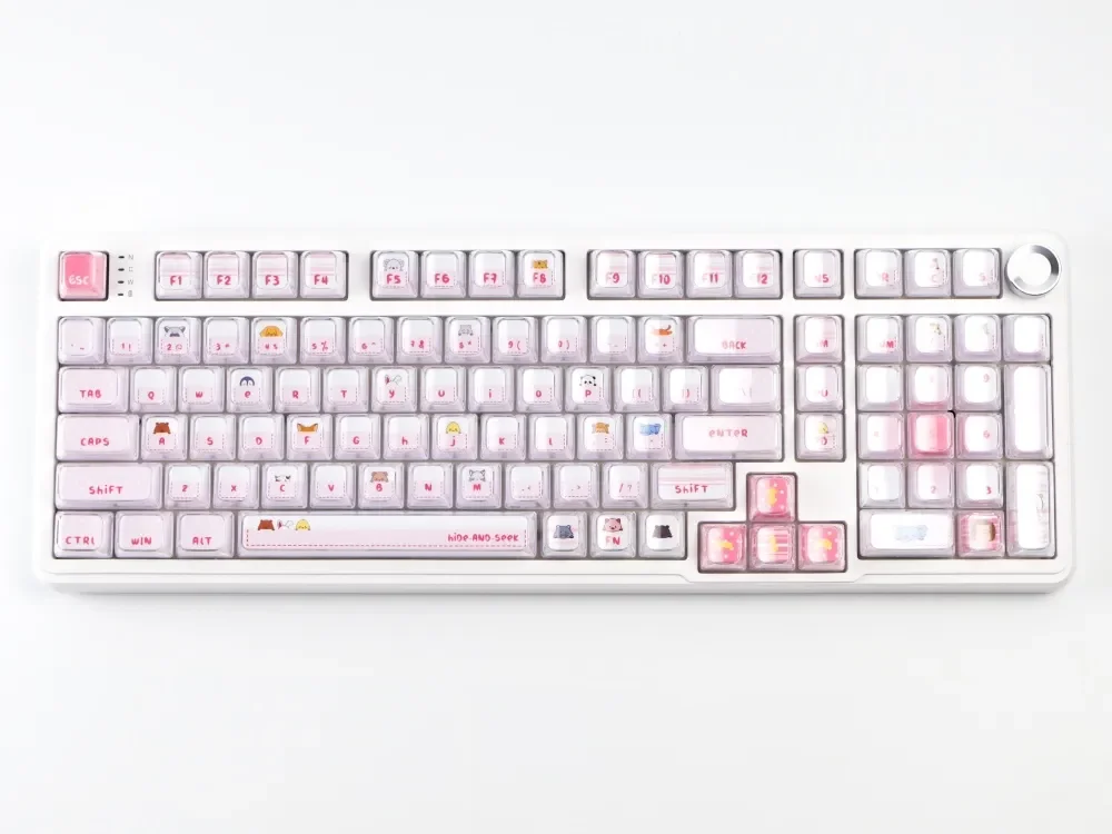 Whimsical pink cat keycap set peeks playfully from its crystal jelly home, showcasing sweet hues for mechanical keyboards.