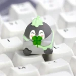 Whimsical green positive penguin keycap, handcrafted from smooth resin, adding a vibrant accent to any mechanical keyboard.