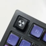 Sleek black ABS radiation keycap showcasing a vibrant, backlit nuclear hazard symbol for an edgy, distinctive custom keyboard.