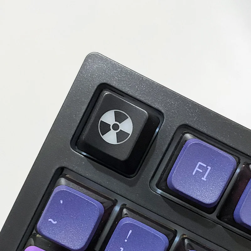 Sleek black ABS radiation keycap showcasing a vibrant, backlit nuclear hazard symbol for an edgy, distinctive custom keyboard.