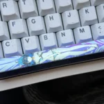 Discover the artisan Roxy Migurdia titanium alloy space key keycap from various angles, highlighting its vibrant anime character art.