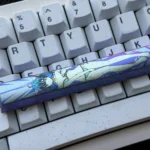 Gallery views of the premium Roxy Migurdia titanium alloy space key keycap, featuring vibrant anime art on polished, colored metal from various angles.