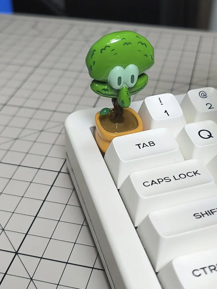 A unique handcrafted resin whimsical Squidward potted plant artisan keycap, shown from a delightful new angle, emphasizing its charming details.