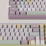 Close-up of unique Taro Pistachio PBT Keycaps set, a sweet pastel delight in purple, green, and cream, showcasing their whimsical dessert theme.