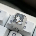 Gallery of Wuthering Waves: Iuno Keycap. Precision-engraved artisan ESC keycap, multiple angles showing intricate anime art on polished titanium.