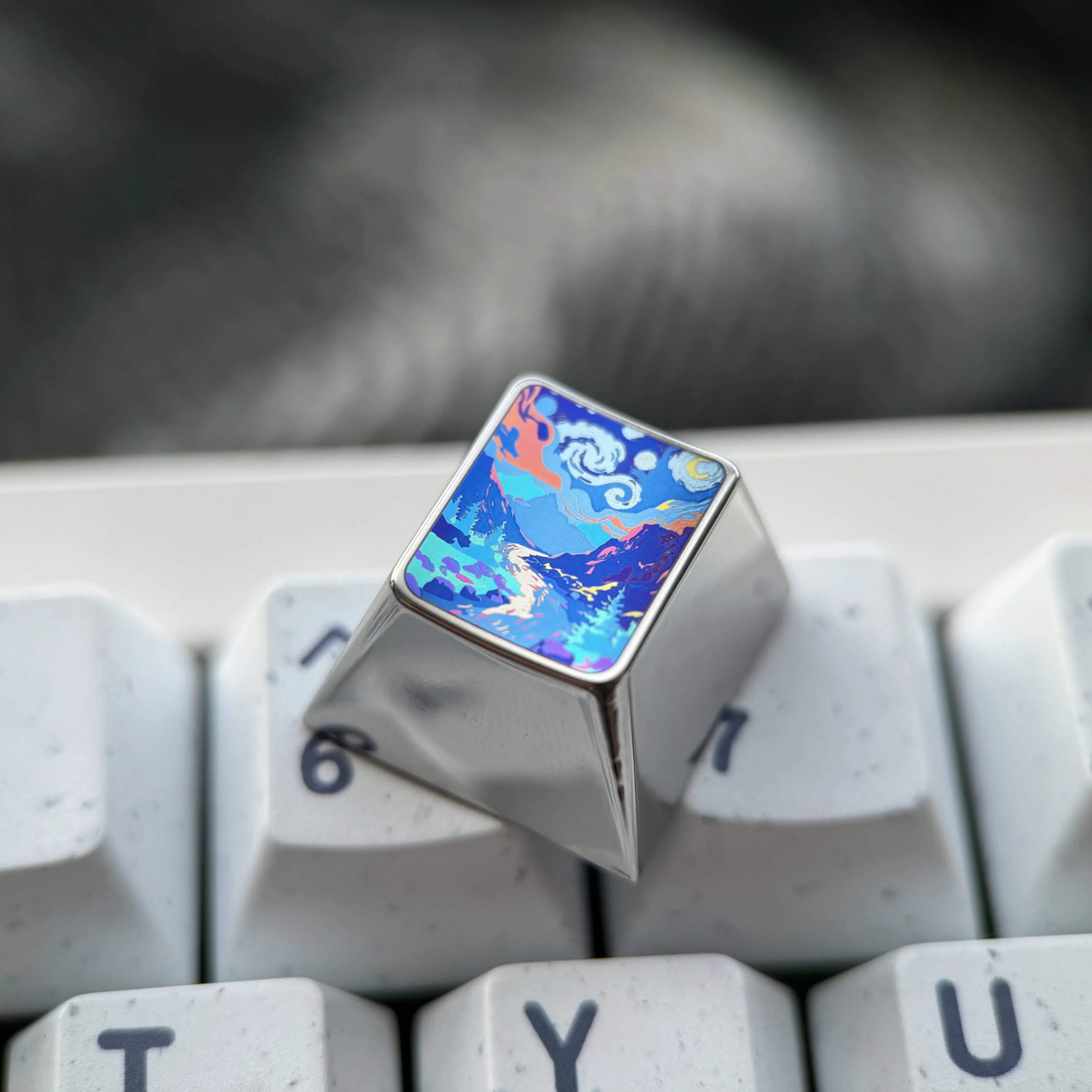 Showcasing the handcrafted titanium mountain valley artisan keycap, highlighting its sculpted peaks and fade-resistant metallic finish from a unique design.