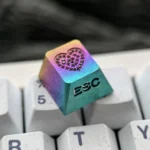 Gallery views of the handcrafted titanium keycap: sparkling gemstone heart inlay, intricate custom engraving, and radiant RGB glow.