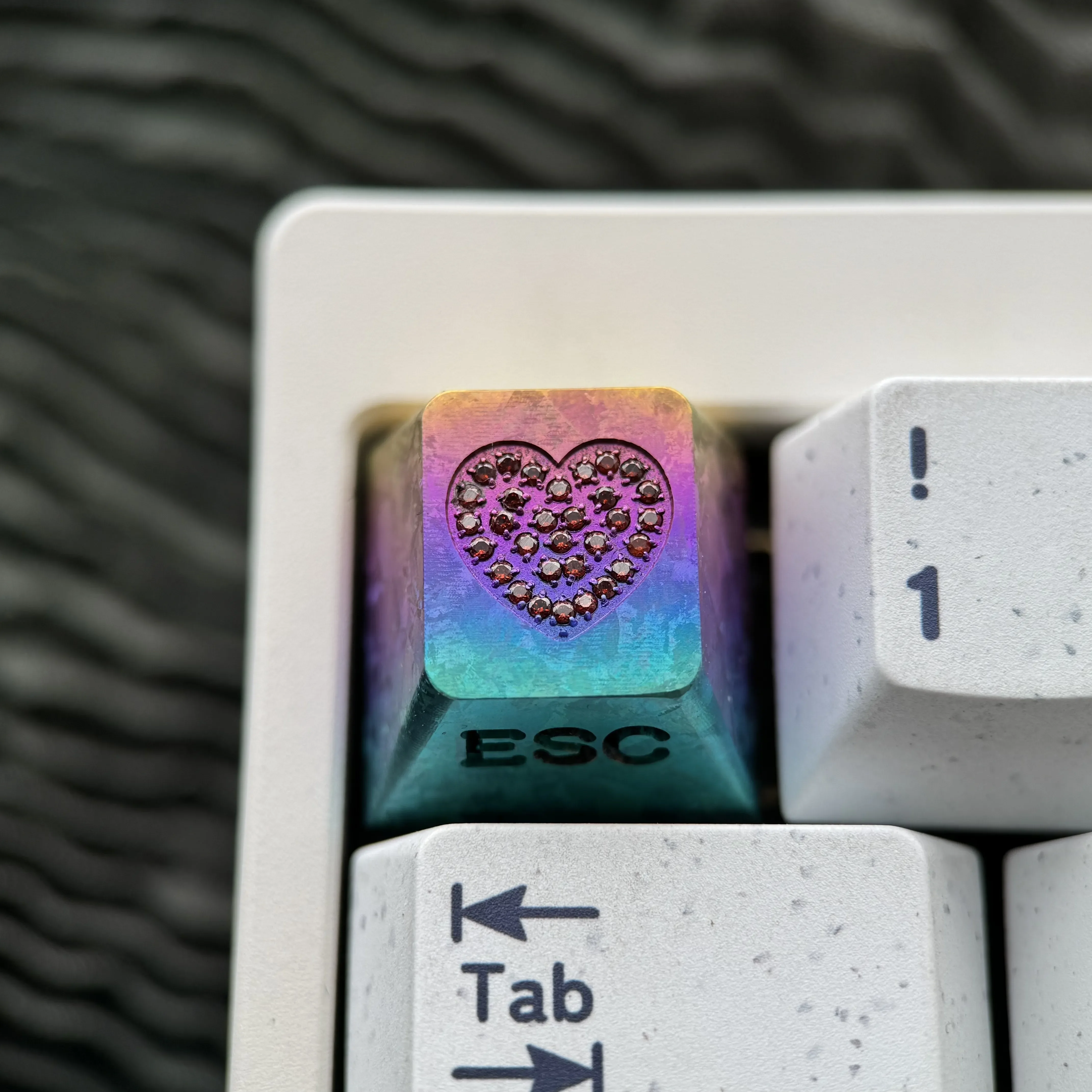 Sparkling gemstone heart inlay on a radiant RGB titanium keycap, showcasing intricate custom engraving and premium craftsmanship.