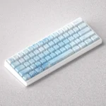 Ethereal Yuki-onna Keycaps PBT set displayed in a gallery, highlighting delicate graphics and icy blue hues inspired by Japanese folklore.