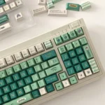 Premium Alhaitham Keycaps Set: Scribe's Elegance full set, shown from various angles. Highlights signature green, grey, gold, and intricate Scribe motifs.