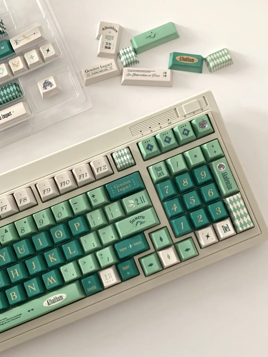 Premium Alhaitham Keycaps Set: Scribe's Elegance full set, shown from various angles. Highlights signature green, grey, gold, and intricate Scribe motifs.