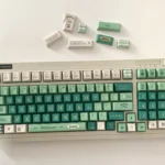 Alhaitham Keycaps Scribe's Elegance full set, showcasing premium green, grey, gold Scribe motifs from various angles.