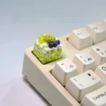 Close-up views of vibrant handcrafted artisan dessert keycaps, showcasing realistic miniature ice cream and cake designs from multiple angles.